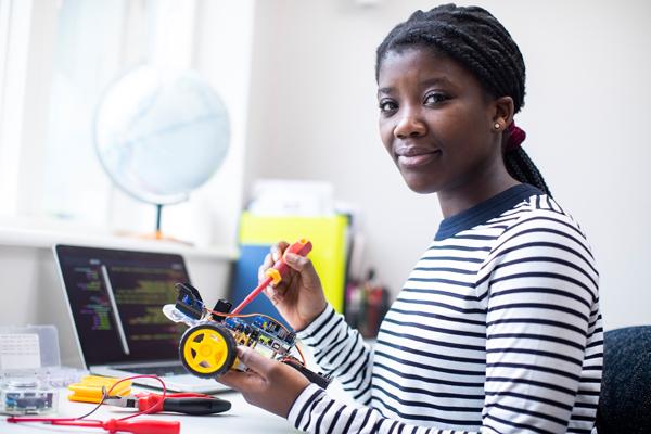 A young woman works on a small engineering project.