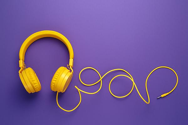 黄色有线耳机在紫色的背景.